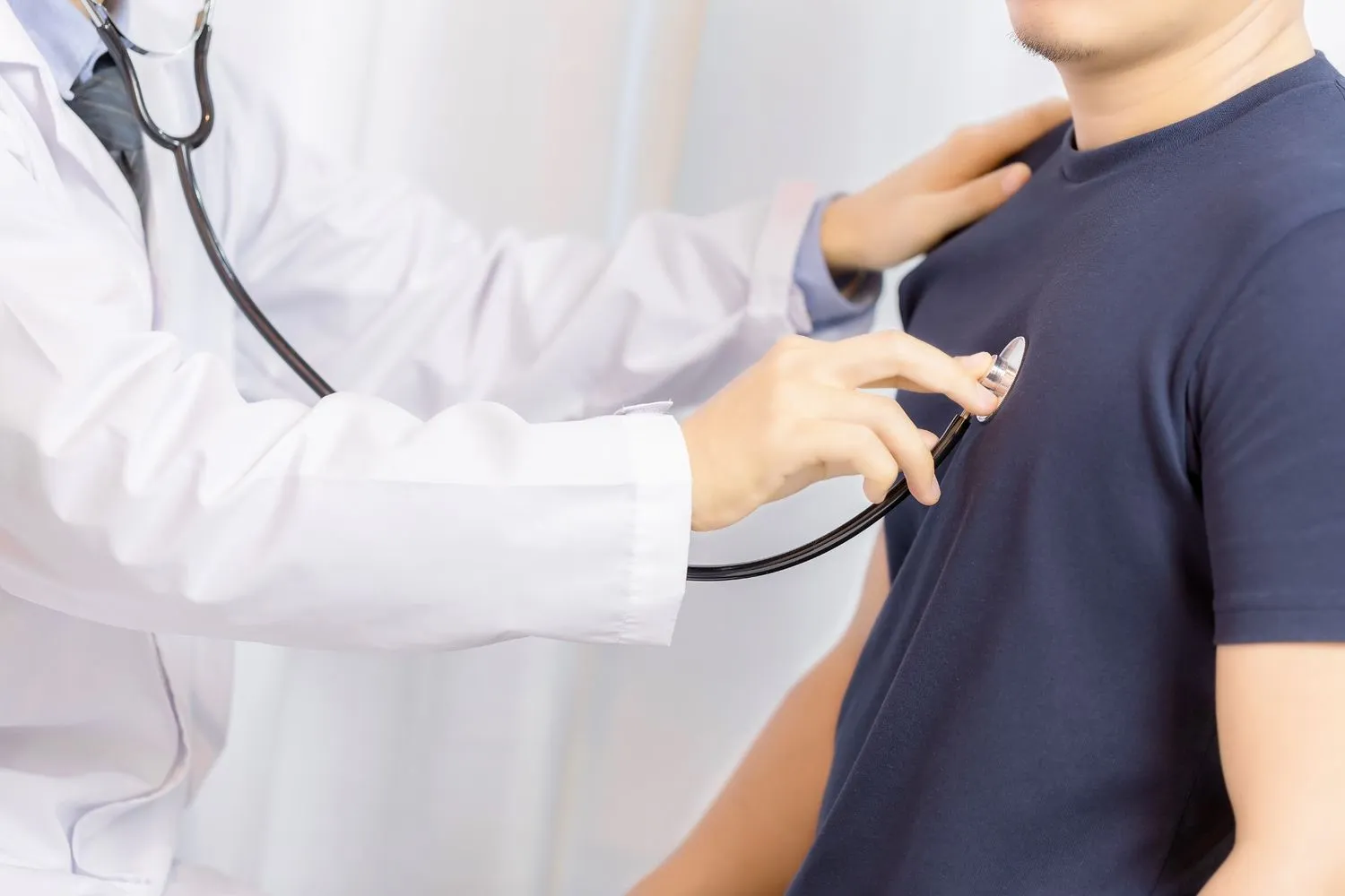 Cardiologist examining a young man for heart rhythm disorder using a stethoscope at a hospital in Chennai